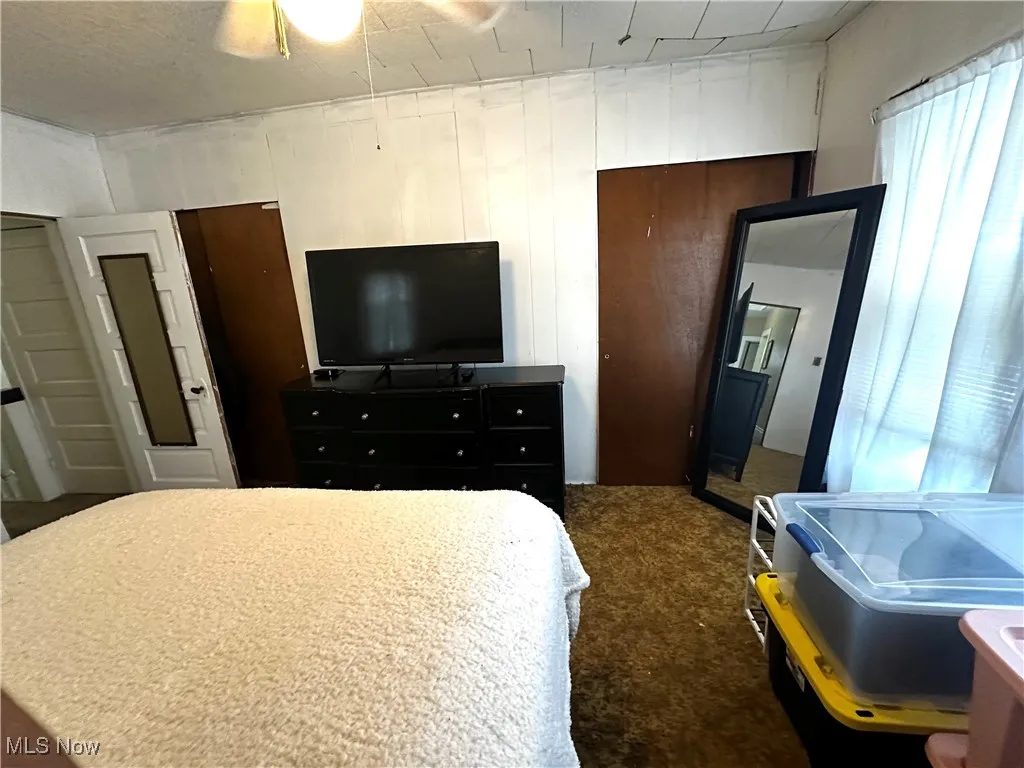 Carpeted bedroom featuring ceiling fan