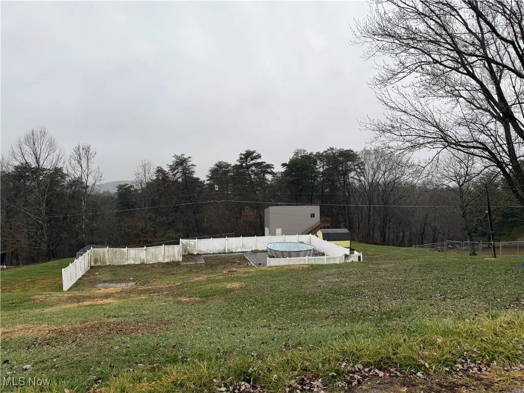 View of storm shelter with a lawn and a wooded view