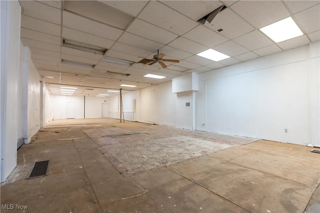 Unfurnished room with a drop ceiling and ceiling fan