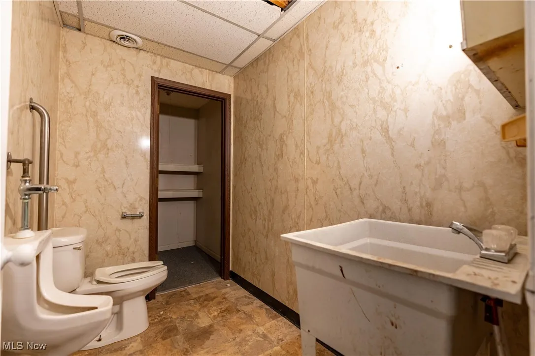 Bathroom featuring a paneled ceiling and toilet