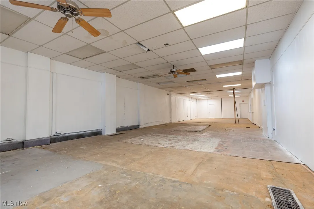 Basement featuring ceiling fan and a paneled ceiling