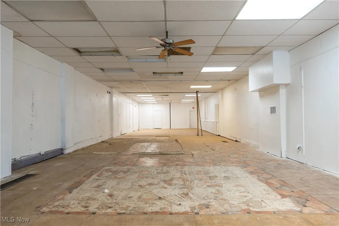 Basement featuring a paneled ceiling and ceiling fan