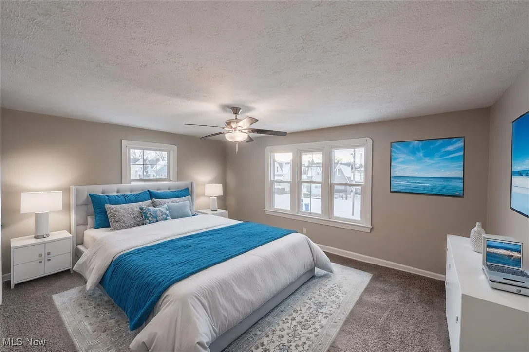 Carpeted bedroom with ceiling fan and a textured ceiling (Virturally Staged)