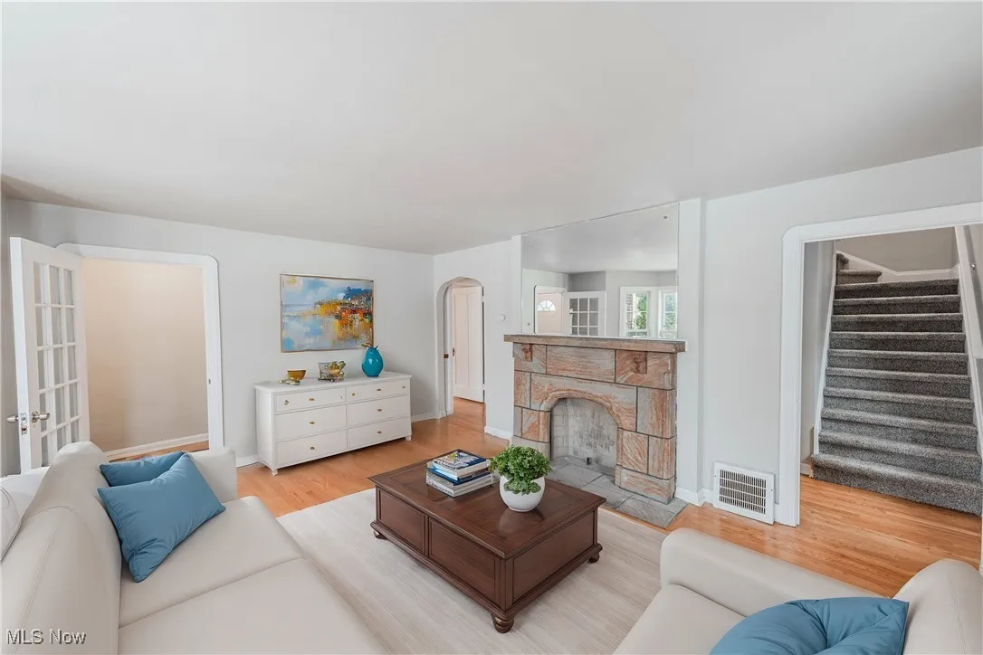 Living room featuring a stone fireplace and light hardwood / wood-style flooring (Virturally Staged)