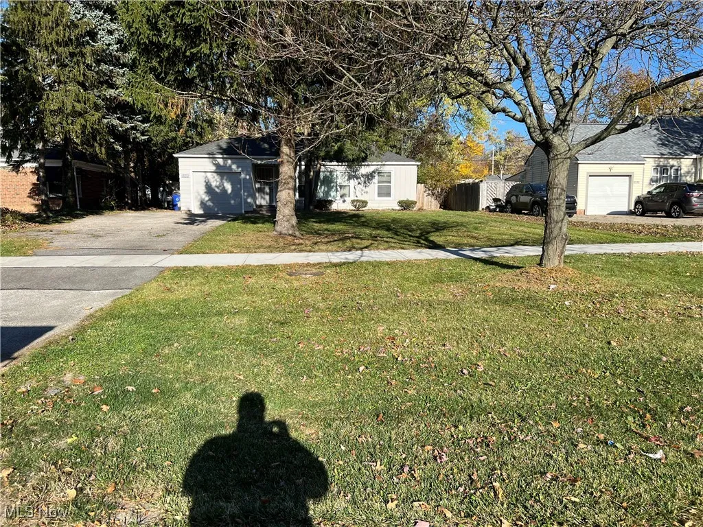 View of front of property featuring a garage and a front lawn