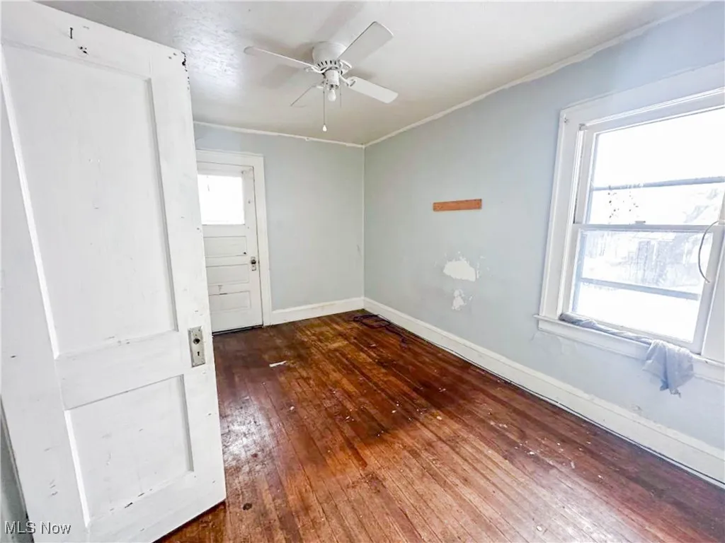 Spare room with dark hardwood / wood-style floors and ceiling fan
