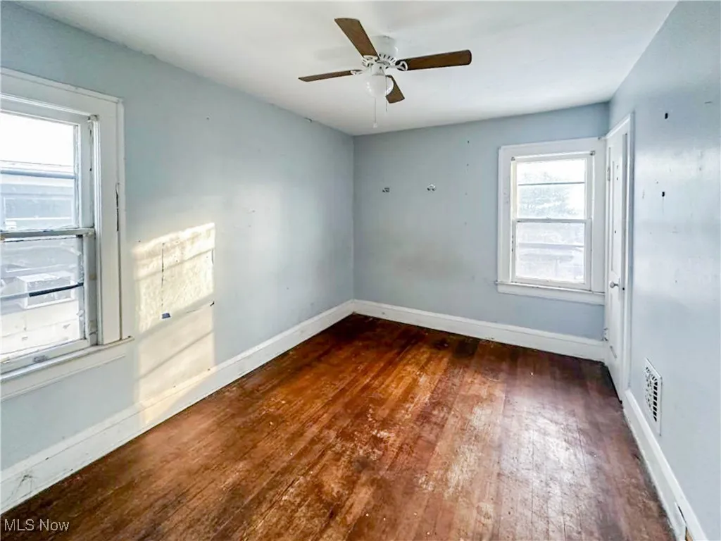 Spare room with dark hardwood / wood-style floors and ceiling fan