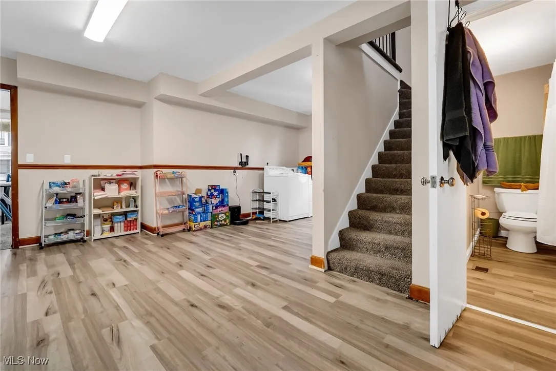 Recreation room featuring baseboards, washer / dryer, and wood finished floors