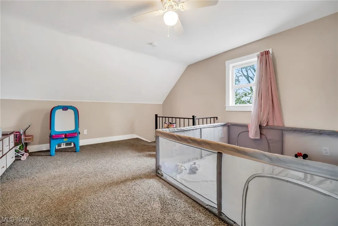 Unfurnished bedroom with baseboards, a ceiling fan, carpet flooring, and vaulted ceiling