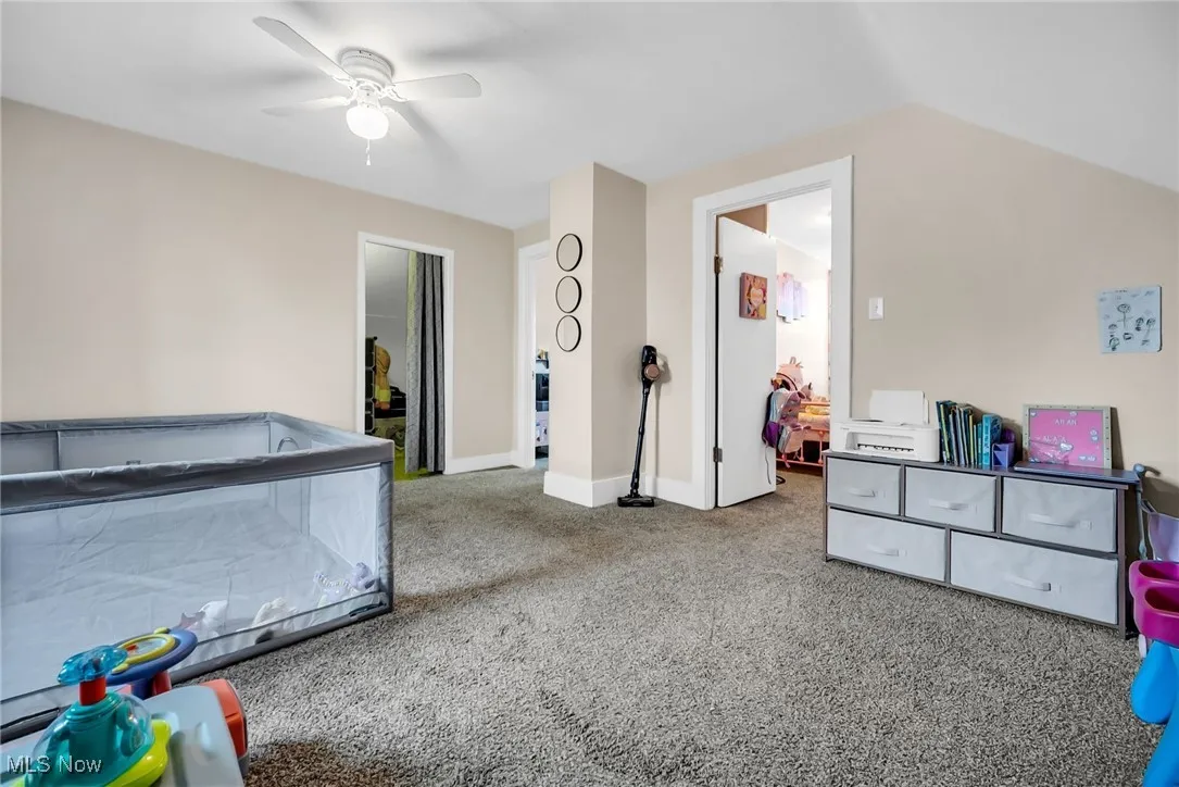 Game room with carpet, a ceiling fan, vaulted ceiling, and baseboards