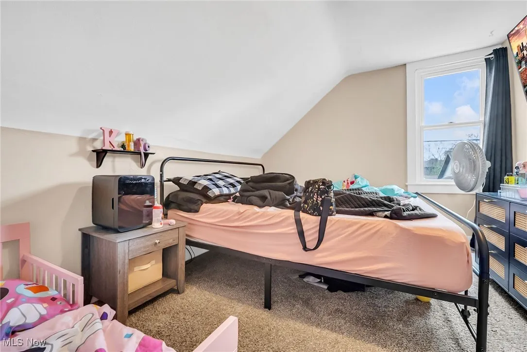 Carpeted bedroom featuring vaulted ceiling