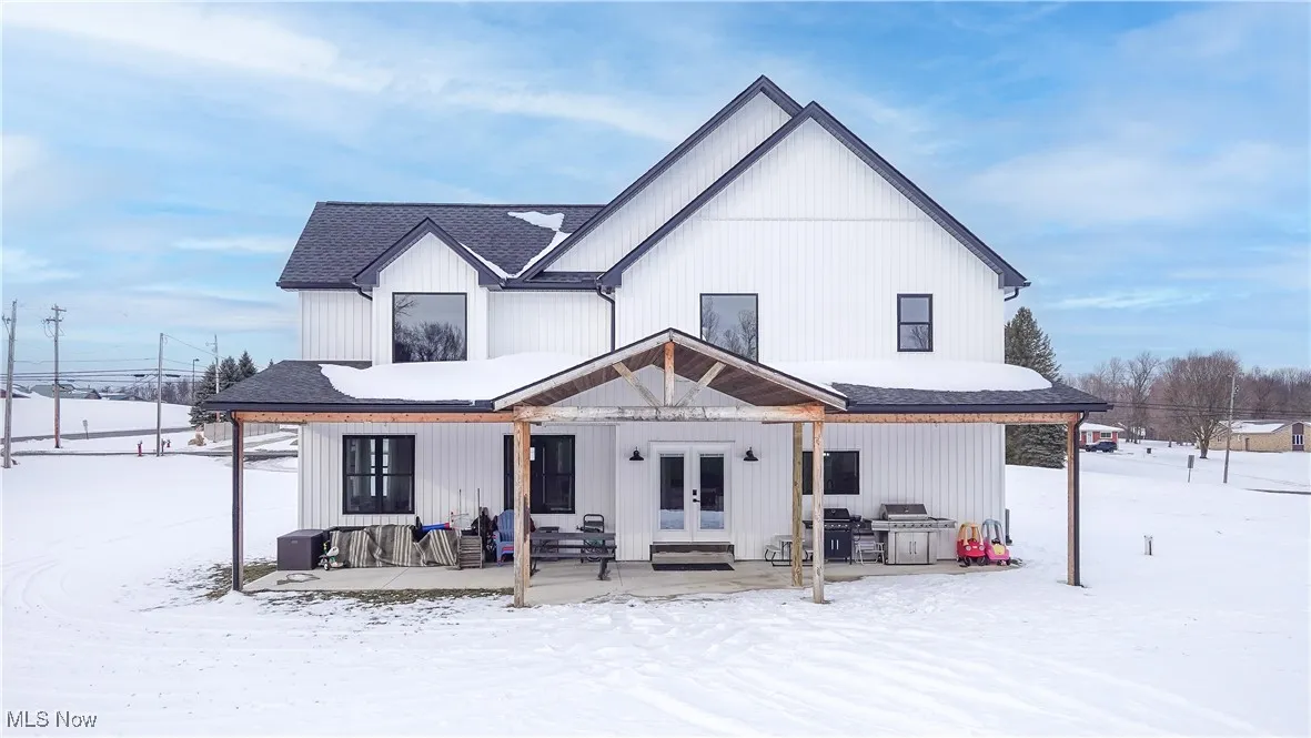 Snow covered property with french doors
