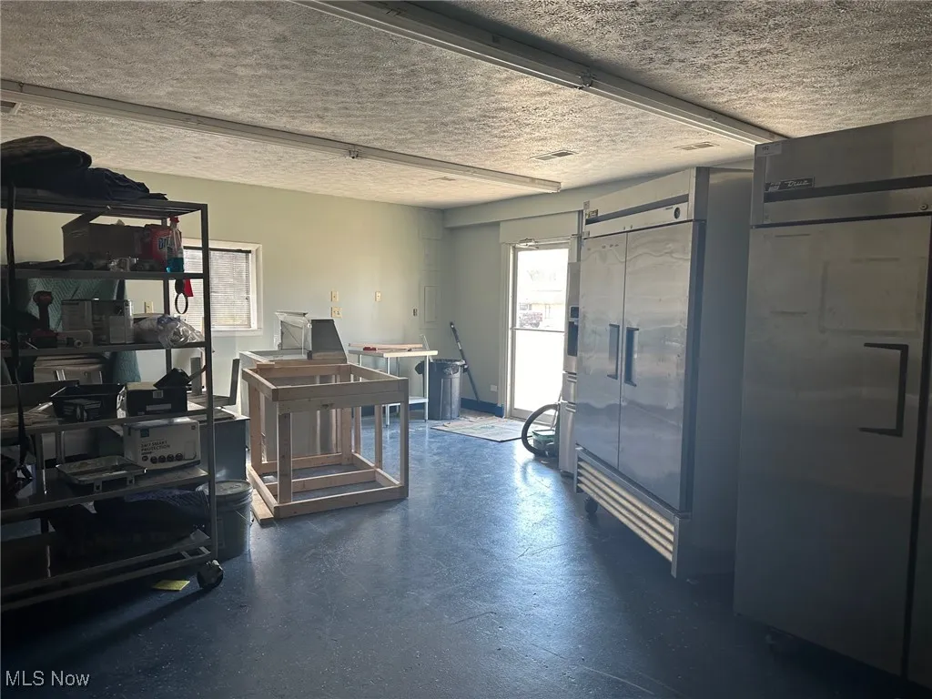 Misc room featuring a barn door and a textured ceiling