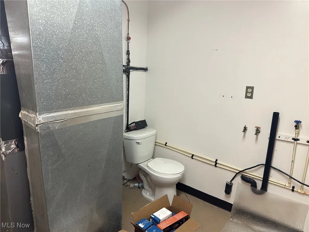 Bathroom featuring concrete floors and toilet