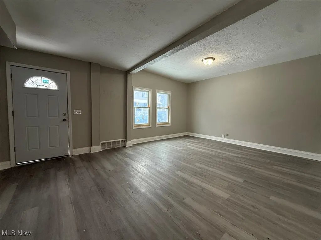Foyer with dark hardwood / wood-style floors and a textured ceiling