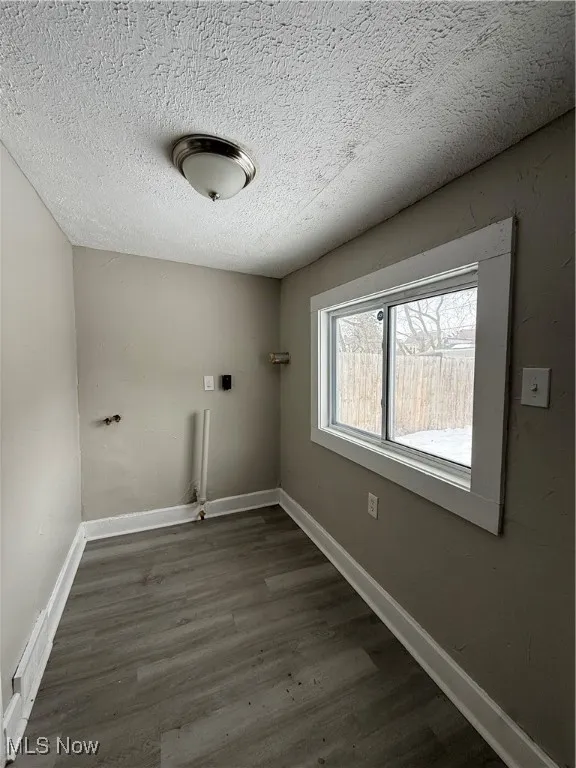 Washroom featuring dark wood-type flooring and a textured ceiling