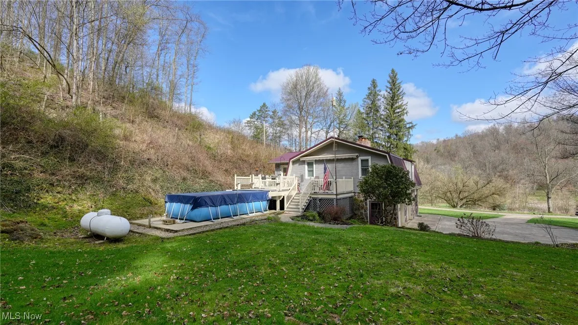 View of yard with a deck and a covered pool