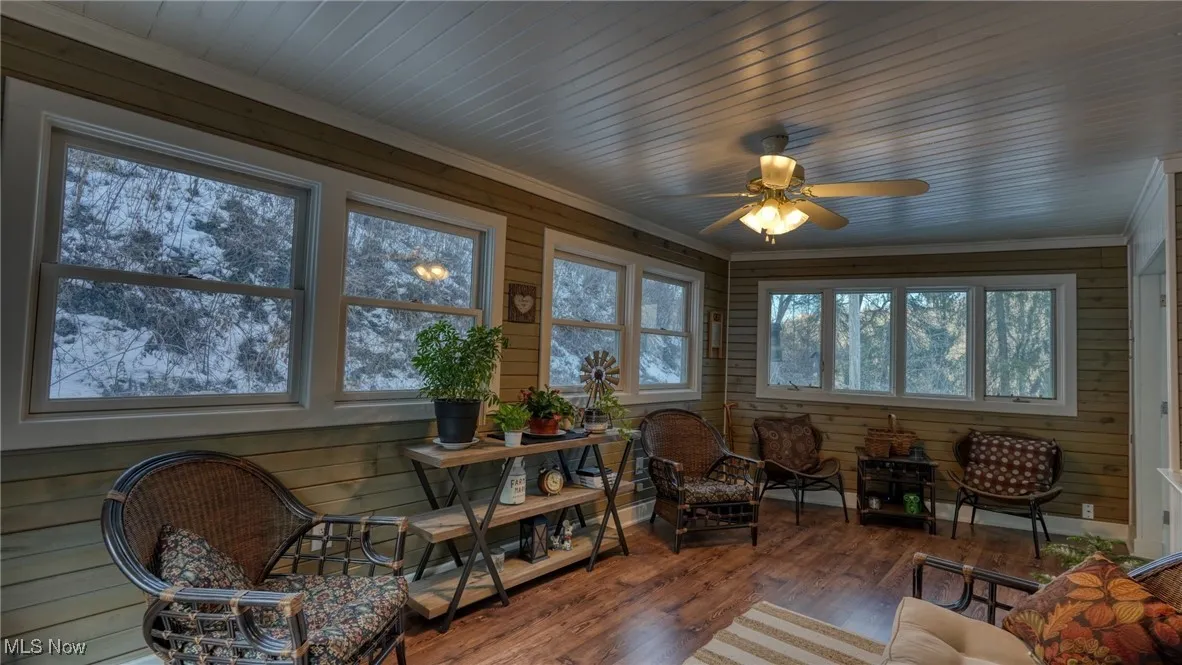 Sunroom featuring ceiling fan and wood ceiling