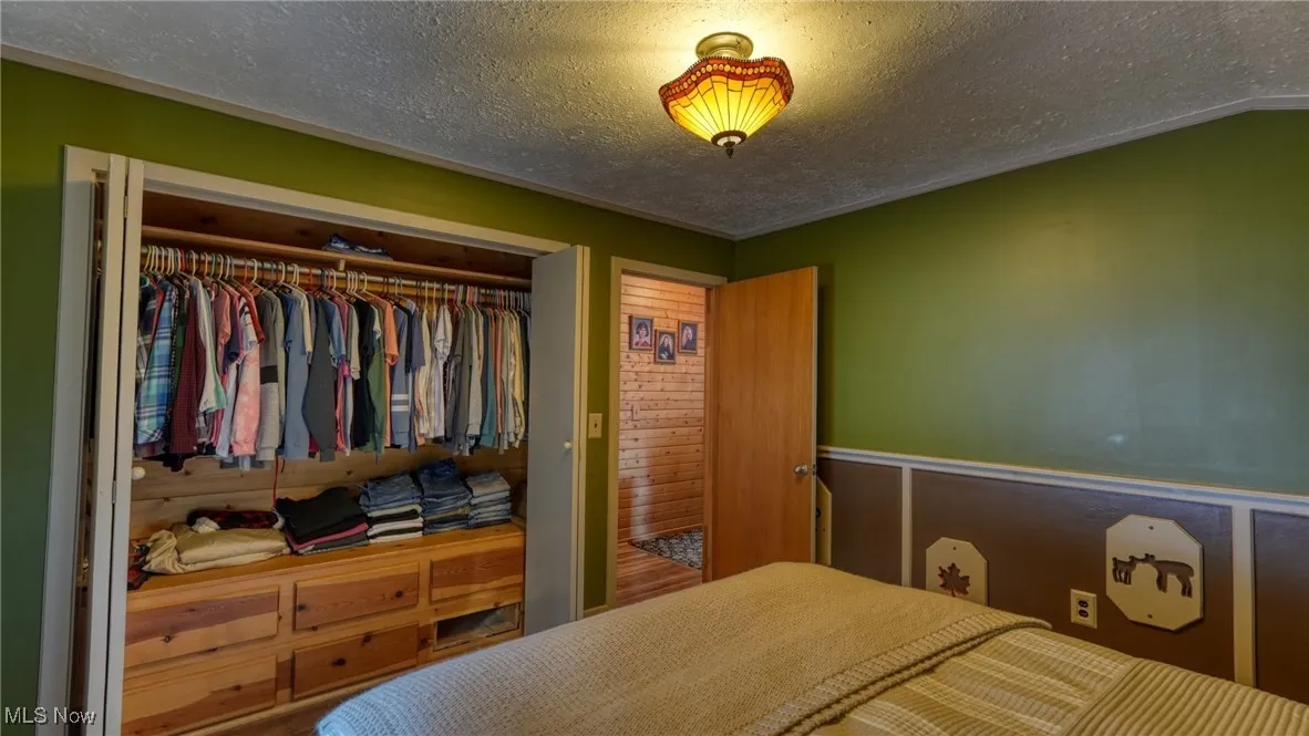 Bedroom featuring a textured ceiling and a closet