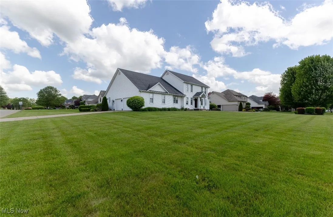 View of front of home with a garage, a front lawn, and driveway