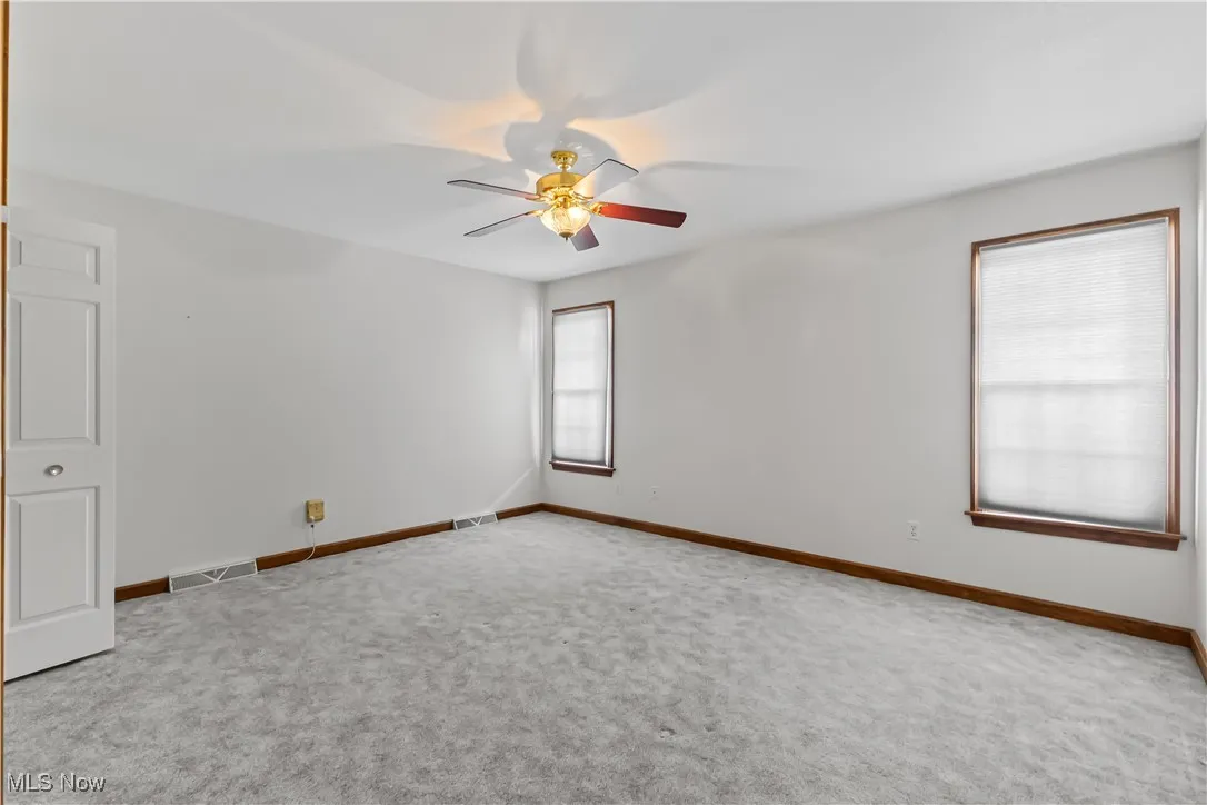 Carpeted empty room with ceiling fan