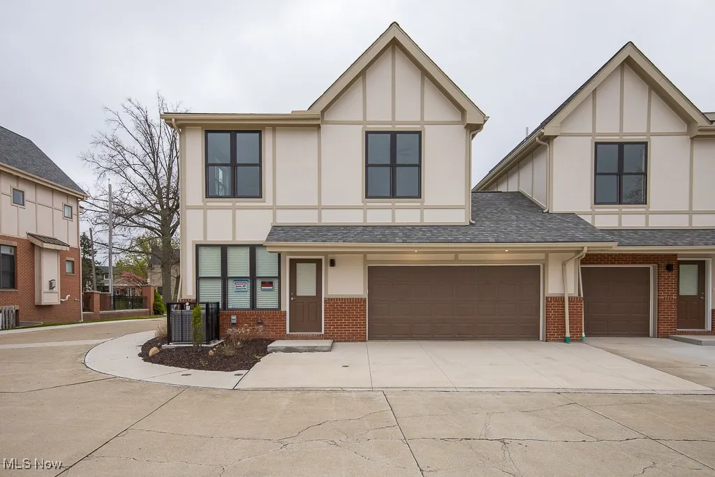 Tudor-style house featuring a garage and central AC