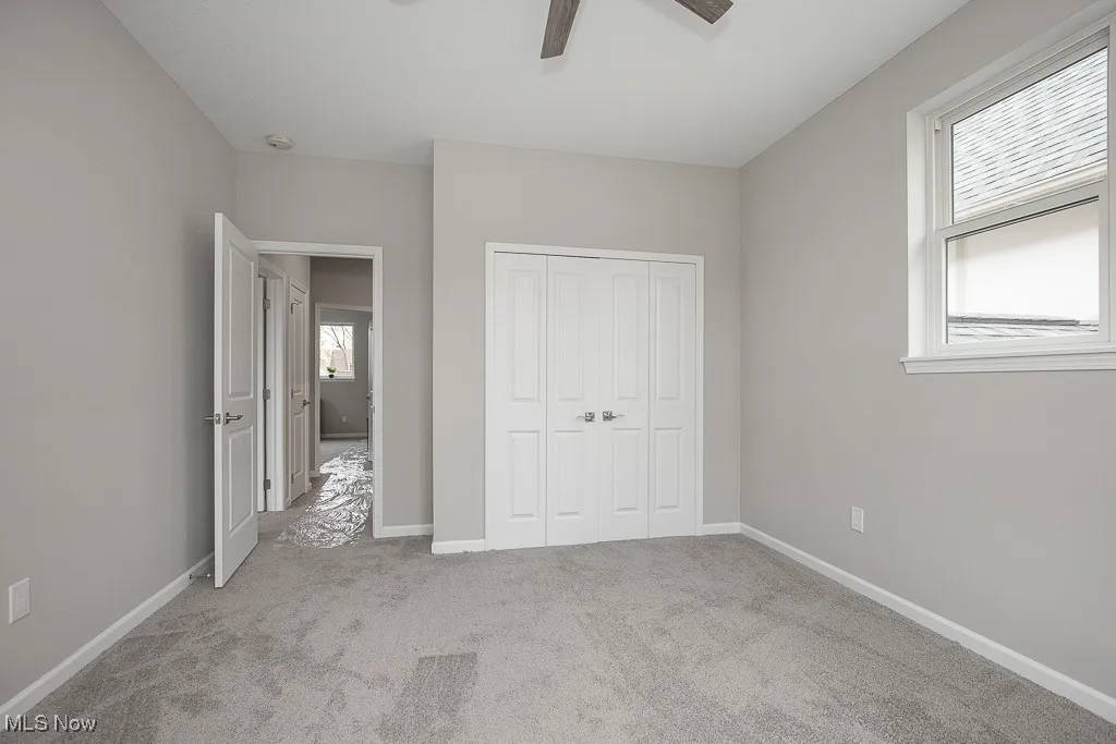 Unfurnished bedroom featuring a closet, ceiling fan, and carpet flooring