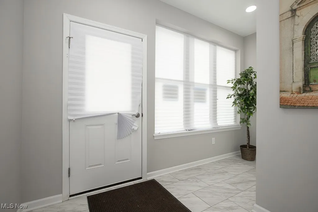 Doorway featuring a healthy amount of sunlight and light tile floors