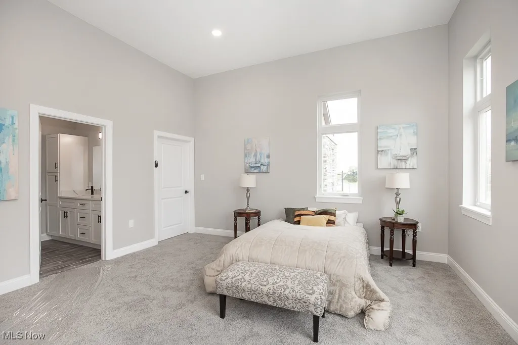 Bedroom with light wood-type flooring and connected bathroom