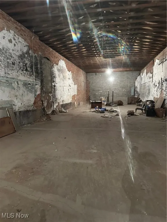 Main Floor featuring brick wall and concrete flooring
