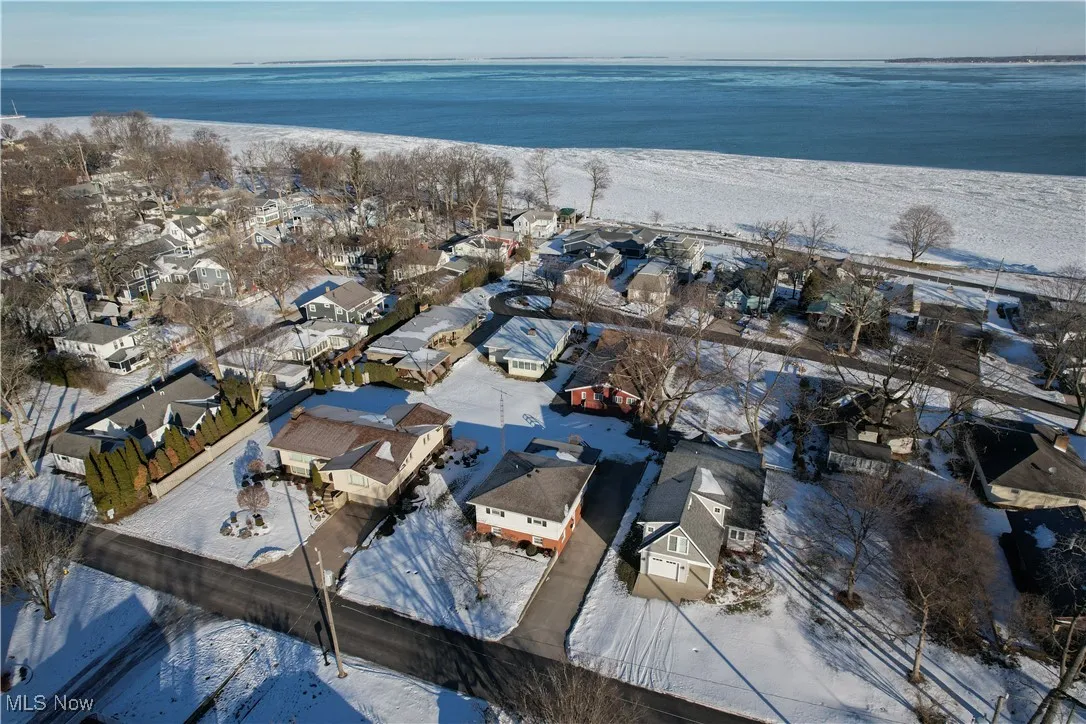 Snowy aerial view featuring a water view