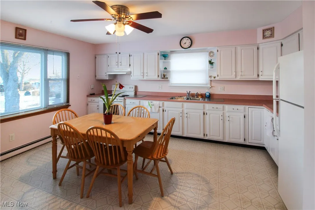 Dining space with ceiling fan, sink, and a baseboard heating unit