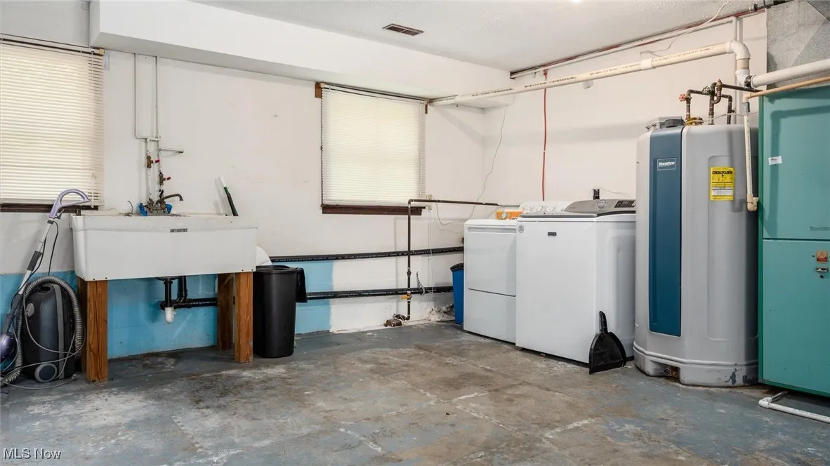 Basement featuring water heater and independent washer and dryer