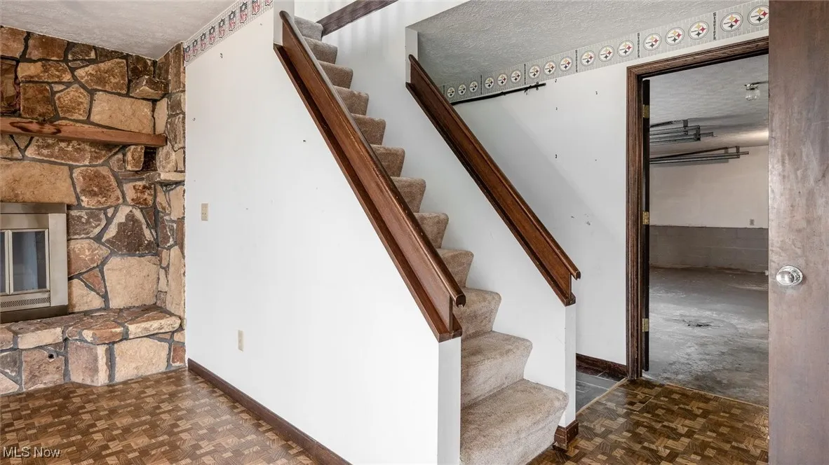 Staircase with parquet floors and a textured ceiling