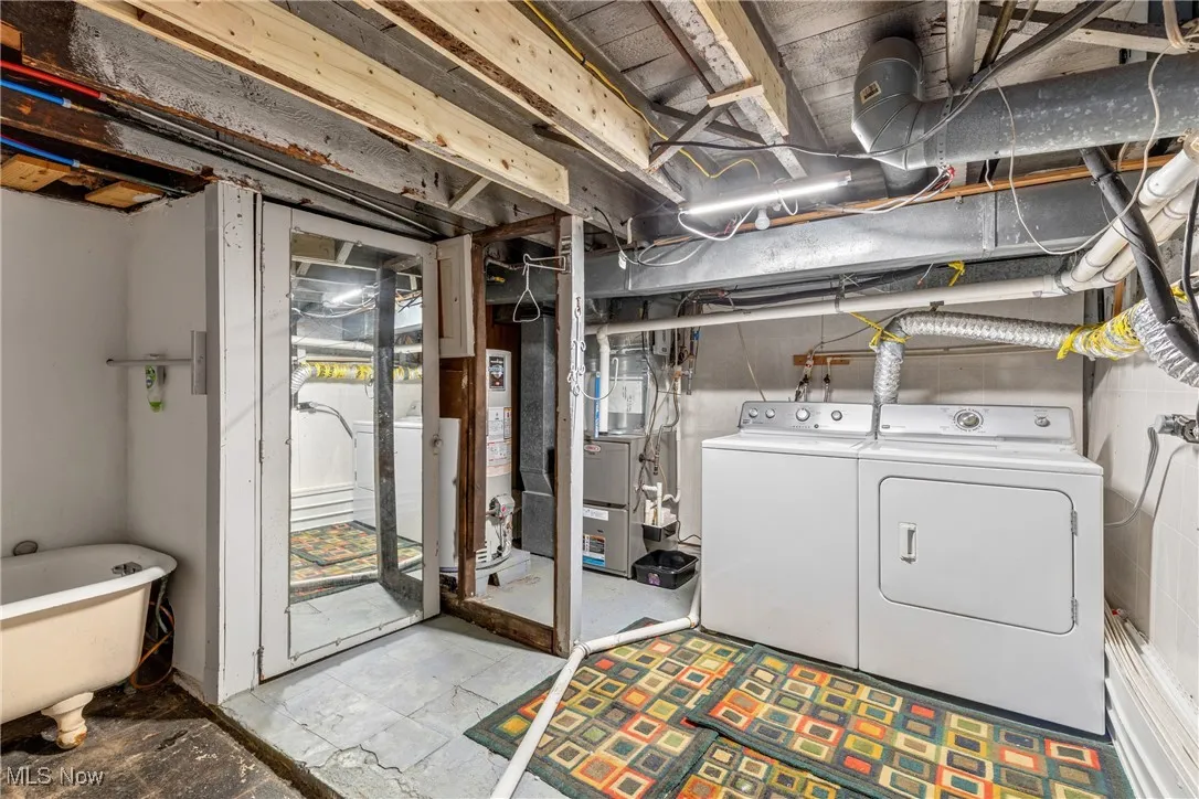 Basement with heating unit, water heater, and washing machine and clothes dryer