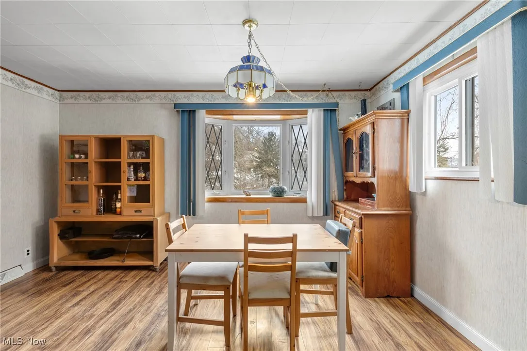 Dining area featuring crown molding and wood-type flooring