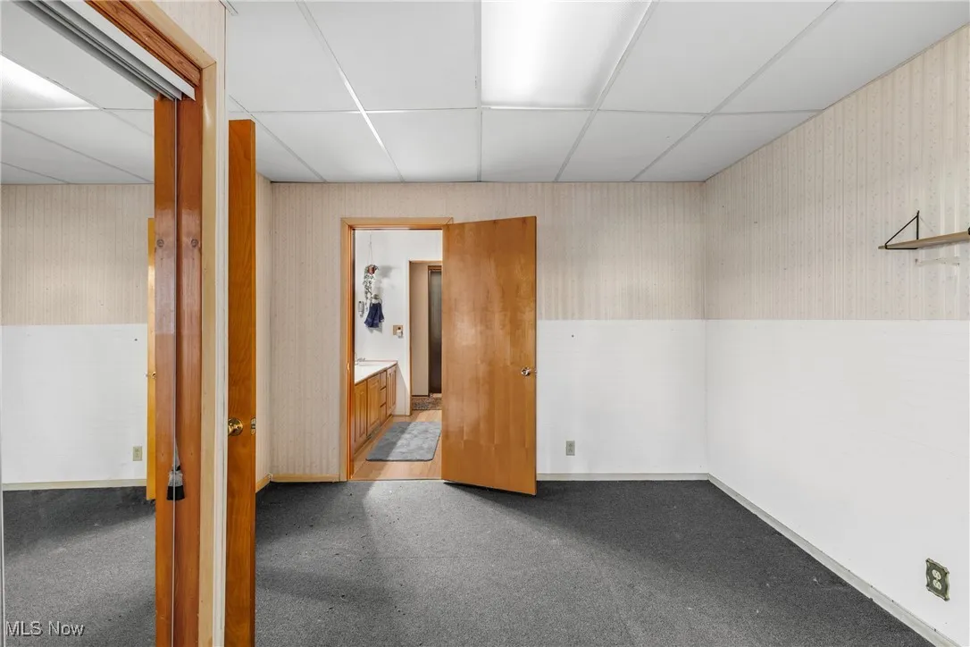 Carpeted empty room featuring a paneled ceiling