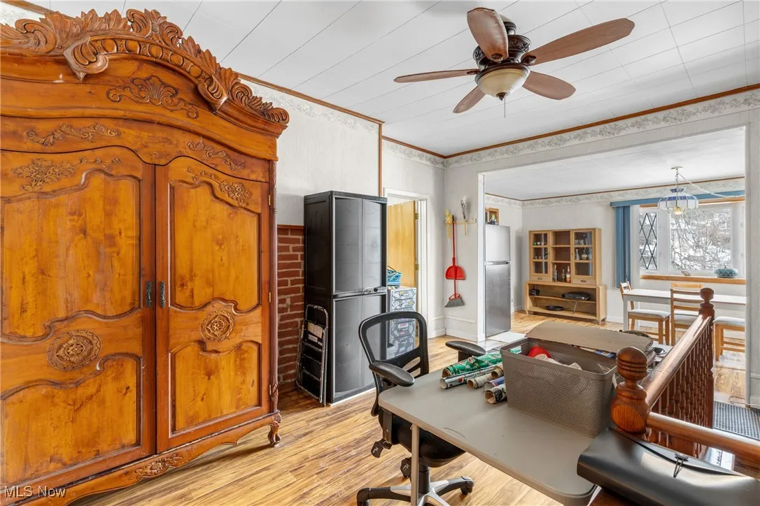 Office featuring ceiling fan, ornamental molding, and light hardwood / wood-style flooring