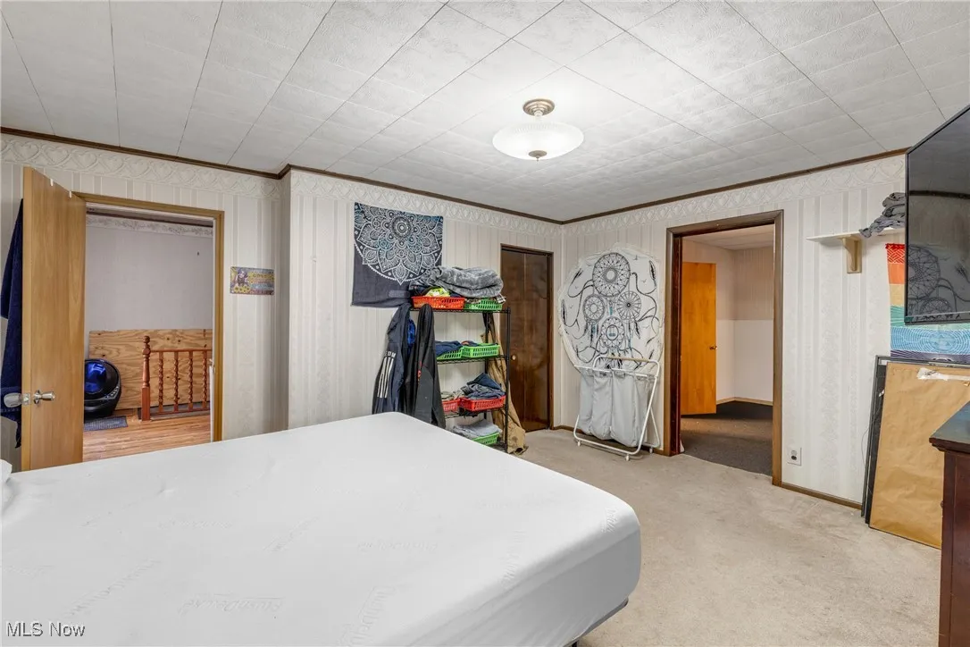 Carpeted bedroom featuring ornamental molding