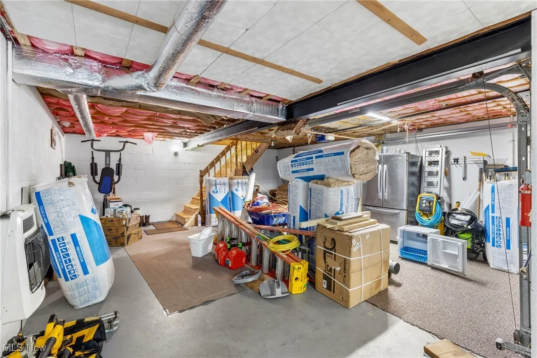 Basement featuring stainless steel fridge and heating unit