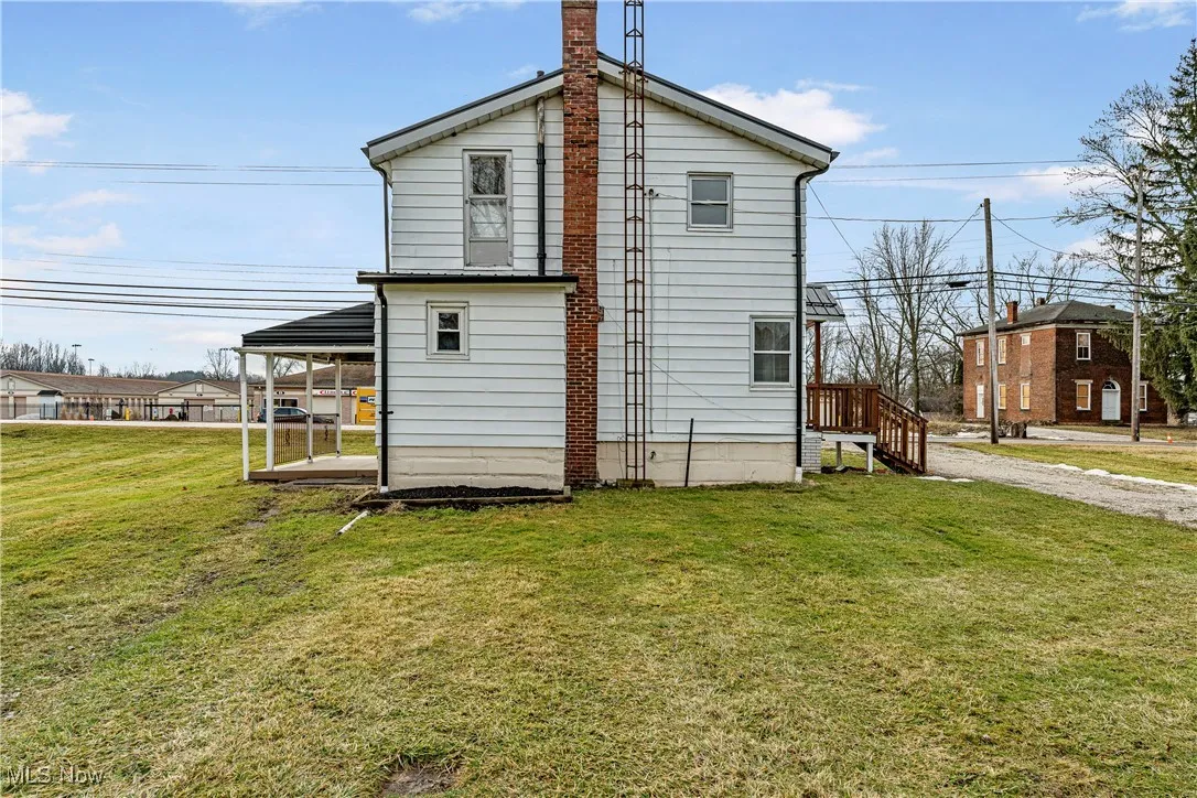 View of side of property with a lawn and a carport
