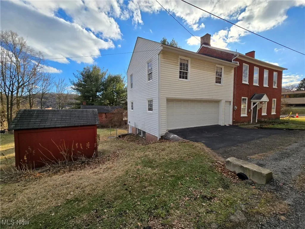 View of property exterior with a garage and a yard
