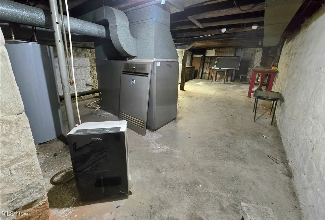 Basement featuring heating unit and water heater