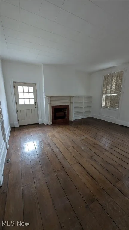 Unfurnished living room with dark hardwood / wood-style flooring