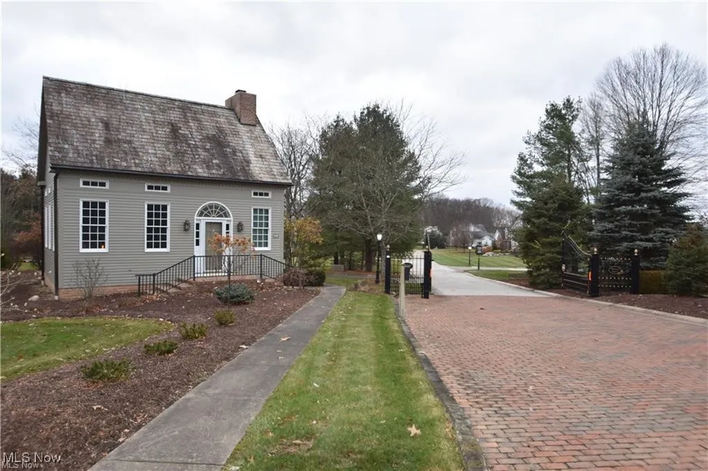 View of gated entrance with a front lawn