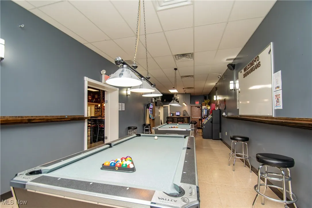 Rec room featuring a drop ceiling, billiards, and indoor bar