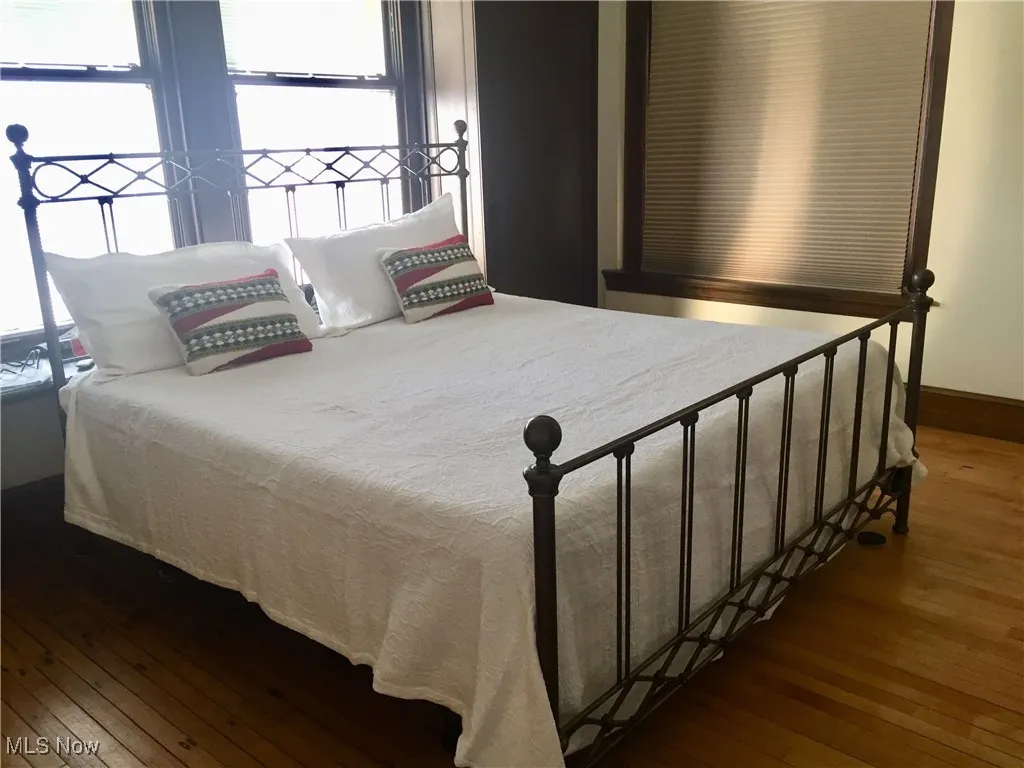 Bedroom with dark hardwood / wood-style floors