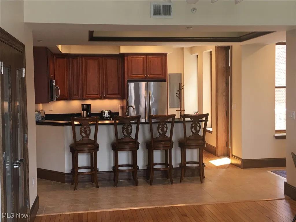 Kitchen featuring appliances with stainless steel finishes, a kitchen breakfast bar, kitchen peninsula, and light wood-type flooring