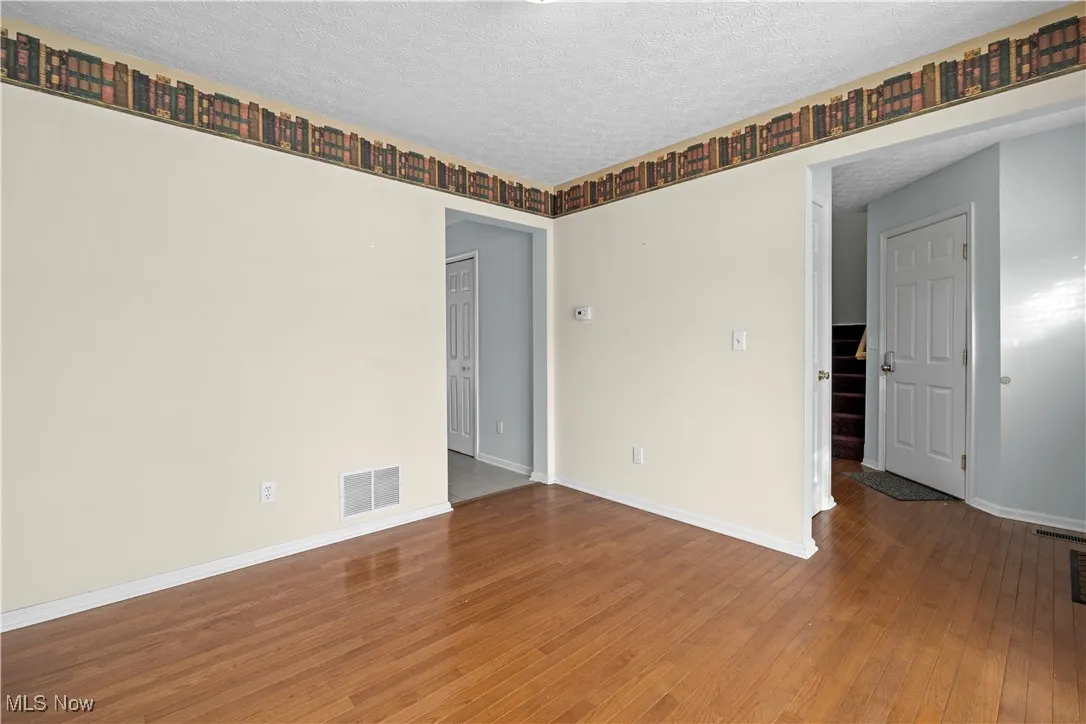 Unfurnished room with wood-type flooring and a textured ceiling