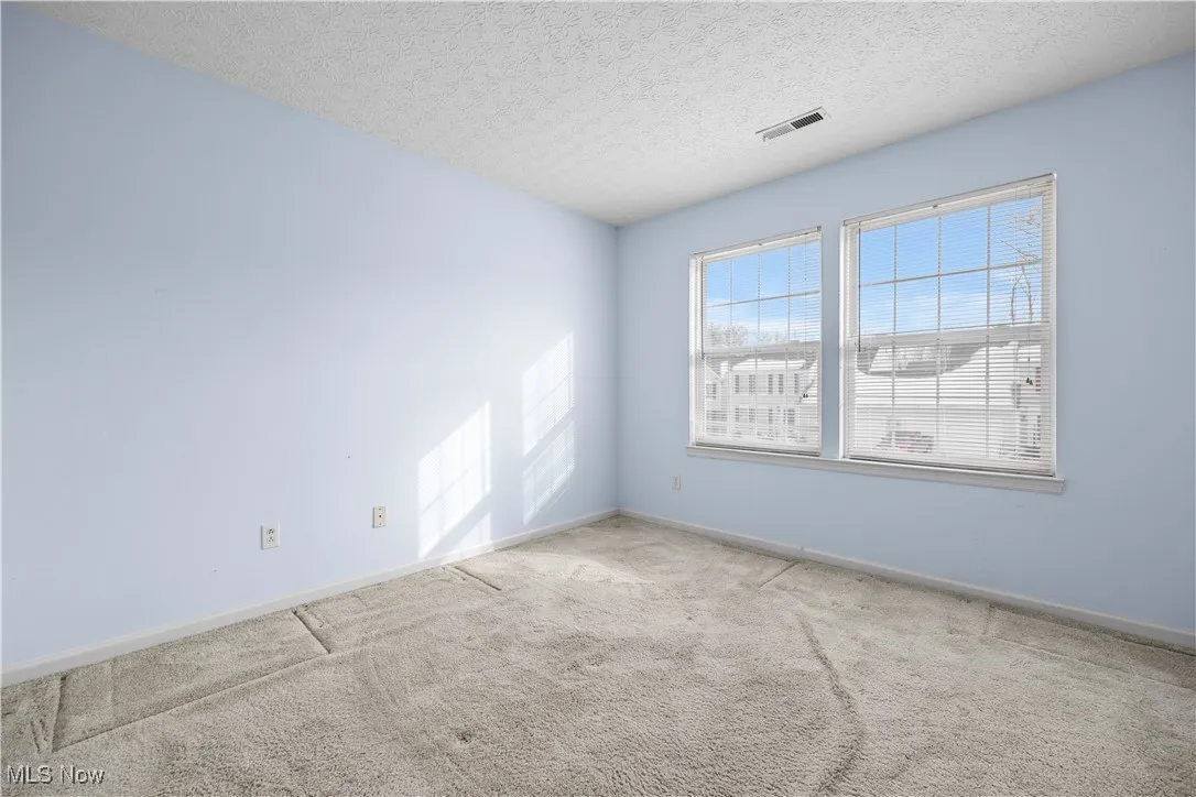 Spare room featuring a textured ceiling and carpet